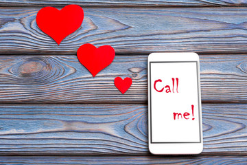 Call me! text on white phone with red hearts. The idea of communication with a loved one, declaration of love