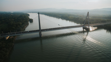 Drone above the Megyeri bridge in Budapest Hungary. Cars cross the bridge. Budapest in the background.