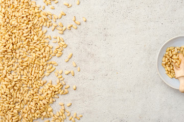 Organic pine nuts, pine nuts in bowl. Flat lay, top wives, copy space.