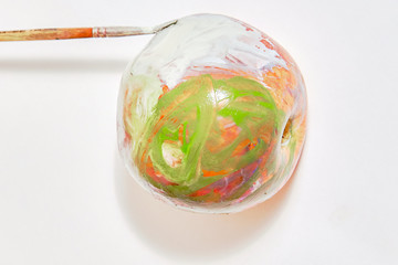 Apple creatively painted with watercolor paints by a child's hand