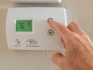 Setting digital thermostat to cool and programming air conditioning to energy saving temperature of...