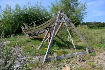 Fototapeta na wymiar Historical boat construction frame in the reconstructed Viking village Hedeby on the inlet Schlei of the Baltic Sea in Northern Germany, blue sky, copy space