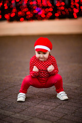 A little, beautiful girl in red clothes and a cap.