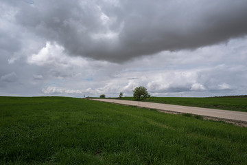 A road crosses the green fields under a stormy sky, Uclés, Cuenca, Spain