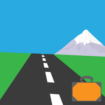 A rough road with a white dotted dividing strip and green flat grass on the edge of the roadway and mountain on the horizon and a suitcase on the side of the road