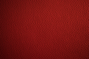 Leather texture close up. Dark red fashionable background, top view. Stylish wallpaper of snake skin. Rough surface of maroon color.