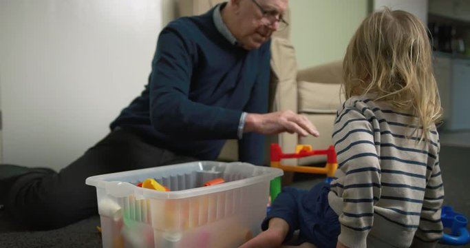 Preschooler and his grandfather playing with marble run