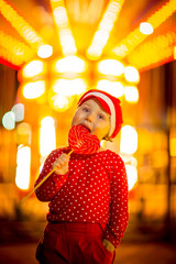 Little girl in red clothes and cap eats candy