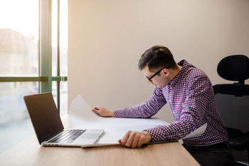Lateral view of businessman/architect/ engineer/in casual shirt