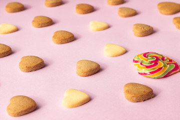 Heart shaped cookies on pink paper background. Cookies pattern, minimal composition. Love concept. Romantic congratulation.