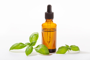 Basil essential oil isolated on white background. Basil oil for skin care, aromatherapy and natural...