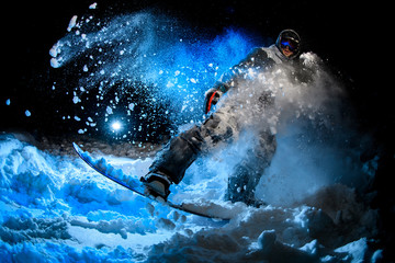 Man snowboarder doing stunts on blue light background