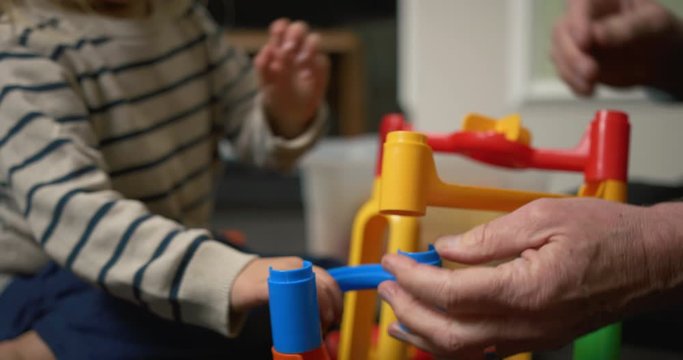 Grandfather and grandson building a marble run at home