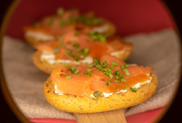 Whole toast with cheese spread and smoked salmon on wooden board