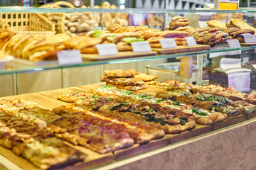 Croissant with ham and cheese. Hot pastries lie on the shelf in the cafe. Buns and bagels in the...