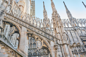 Fototapeta na wymiar Amazing view of old Gothic spires. Milan Cathedral roof on sunny day, Italy. Milan Cathedral or Duomo di Milano is top tourist attraction of Milan.