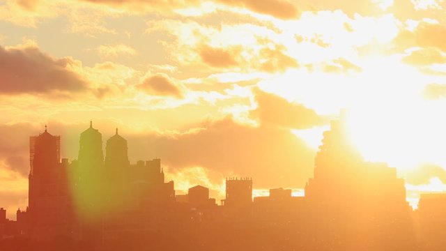 The sky glows by sunset over the Central Park West Residences. Central Park West Residences become silhouettes. Image was captured from Central park.