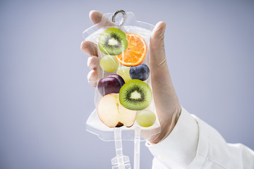 Doctor Holding Saline Bag With Fruit Slices Inside In Hospital