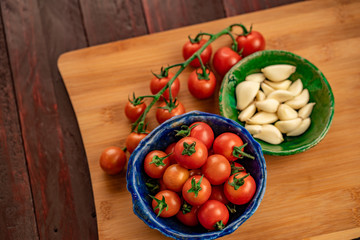 tomates cherry en tabla de madera cuchillo de chef y vegetales ajo cebolla tomillo y pimiento con mantequilla 
