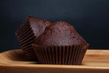 Dark chocolate muffin on wooden dish