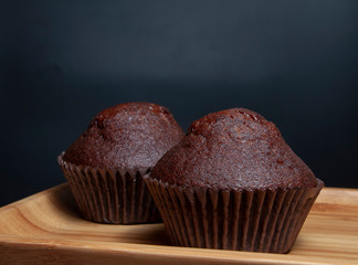 Dark chocolate muffin on wooden dish