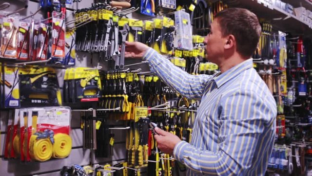 Male customer choose locksmith tools at hardware store