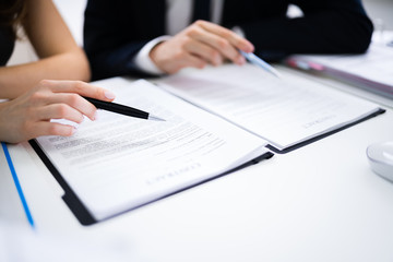 Two Businesspeople Working On Contract Paper