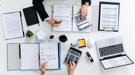 Two Businesspeople Calculating Bills In Office