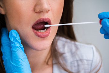 Close-up Of A Doctor Taking Saliva Sample For DNA Test