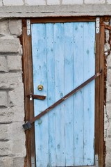 old wooden barn door in blue with old rusty locks