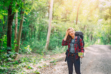 Traveling Tired Asian woman with backpack walking on path the tropical forest looking at the camera and map in green rainforests. Summer holiday and vacation trip , Survival travel, lifestyle concept