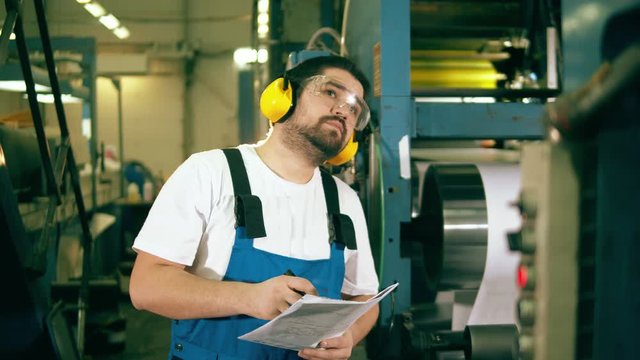 Male worker is observing the working process in a typography unit