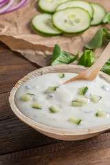 Top view of wooden cutting board on old wooden table top with tablecloth and yogurt sauce dip in a bowl