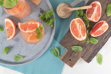 Grapefruit juice with mint in glasses on the table. Refreshing summer cocktail.