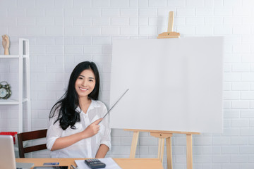 Confident female Asian woman conference speaker coach training on blank chart presentation at an office meeting, businesswoman presenter teach staff team at the corporate business workshop