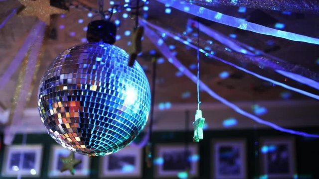 Color HD handheld footage of a spinning disco ball.