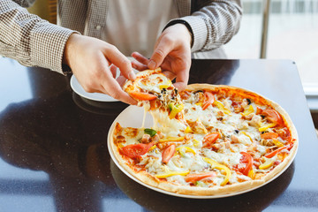 Delicious pizza. Caucasian man take piece of delicious Italian pizza with mozzarella cheese in cafe, restaurant or at home. Fast food pizza