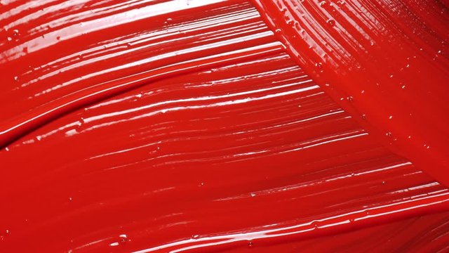 Brush mix red color acrylic painting. Close up.