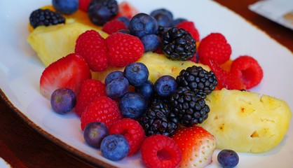 A healthy fruit plate with pineapple and berries