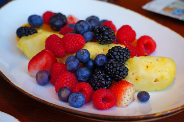 A healthy fruit plate with pineapple and berries