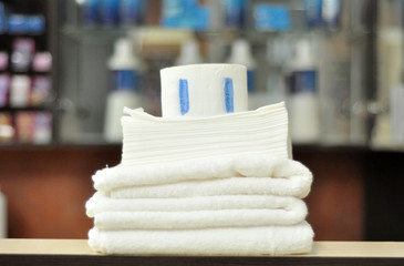 Towels for hairdresser. Beauty salon concept. White clean cotton towels, disposable paper towels,...