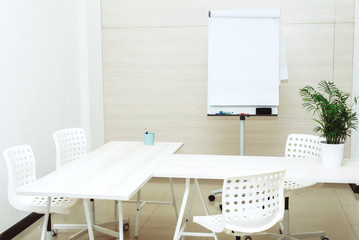 Small bright empty office with chairs, a table and a flipchart. A small cozy room for study at the university. Copyspace, template