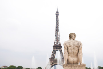 Statue of man with Eiffel tower and the fountain in Paris, France