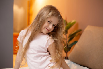 Young girl sitting on bed in the bedroom