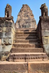 vertical picture of two stone lion statues guarding stairs to ancient angkor wat temple entrance, cambodia