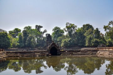reflection of temple and jungle in beautiful old lake with clear water in angkor wat, cambodia, sunken temple