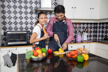 Happy and Smiling young couple cooking food in the kitchen at home