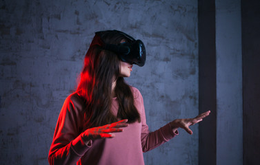 Obraz na płótnie Canvas Reboot. Young woman in virtual glasses spreads her arms in characteristic gesture. Uses a virtual control panel.