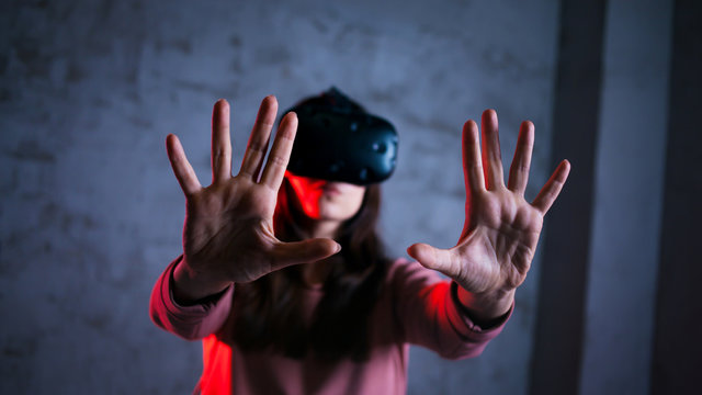 Reboot. Young woman in virtual glasses spreads her arms in characteristic gesture. Uses a virtual control panel.