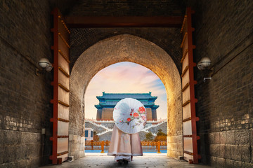 A Chinese girl in a Traditional winter dress at the Archery Tower of Qianmen gate in Beijing, China